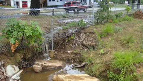 Water crossing Mashapaug Road and eroding the beach at PJ&rsquo;s.