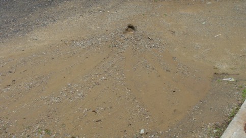 Spontaneous discharge in the middle of Pj&rsquo;s parking lot indicative of a broken underground pipe.